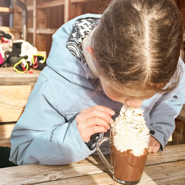 Stärkung auf der Hütte auf der Sella Ronda - Kind trinkt heiße Schokolade